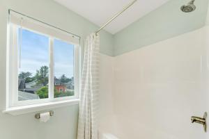 a bathroom with a window and a shower at Seaside Treasure in Seaside +40 photos