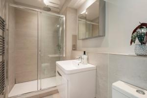 a bathroom with a shower and a sink and a toilet at Vauxhall Skyline Apartment in London