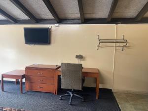 an office with a desk and a tv and a chair at Budget Inn - Madison in Madison