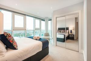 a bedroom with a bed and a large window at Vauxhall Skyline Apartment in London