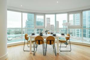 a white dining room with a table and chairs at Vauxhall Skyline Apartment in London