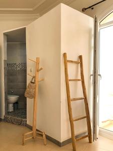 a bathroom with two wooden shelves and a ladder at Arima Surf House in Tamraght Ouzdar