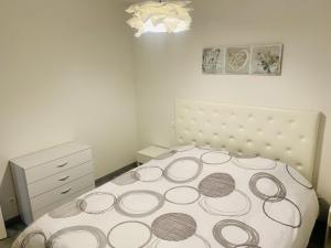 a white bedroom with a bed and a dresser at Le Belvédère in Maîche