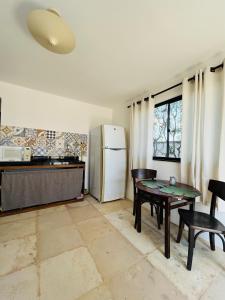 a kitchen with a table and a refrigerator at Aldeias Guajiru Apart in Trairi