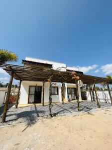 una casa con techo de madera en el desierto en Aldeias Guajiru Apart en Trairi