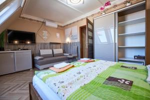 ハイドゥソボスローにあるValentin Deluxe Apartmanのベッドルーム(大型ベッド1台、ソファ付)