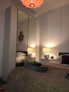 ein Schlafzimmer mit einem Bett und einem großen Spiegel in der Unterkunft Saint Mandé Paris in Saint-Mandé