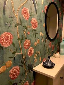 a bathroom with a floral wallpaper with a mirror at Saint Mandé Paris in Saint-Mandé