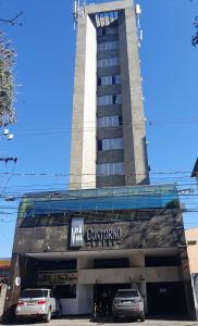 a building with cars parked in front of it at Via Contorno Hotel in Belo Horizonte