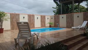 a patio with two chairs and a swimming pool at Flat Raio de Sol - Taipu de Fora in Marau +16 photos