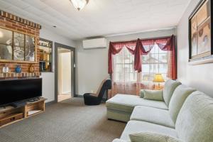 a living room with a couch and a tv at Hillsborough Village Retreat Walk to River! 