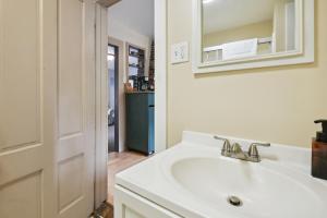 un bagno bianco con lavandino e specchio di Hillsborough Village Retreat Walk to River! a Hillsboro Altre 16 foto