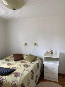 a bedroom with a bed and a white night stand at Talo Merikarvian keskustassa lähellä Merta! in Merikarvia