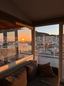 a living room with a couch and a large window at Verde Blue in Kavála