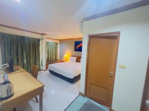 a hotel room with a bed and a desk and a bedroom at Royal Vista in Patong Beach