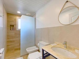 Un baño con inodoro, lavabo y espejo. en KAU KOSTEN, en El Chaltén