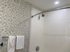 uma casa de banho com um chuveiro e toalhas brancas em Holiday Inn Niagara Falls-Scenic Downtown, an IHG Hotel em Niagara Falls