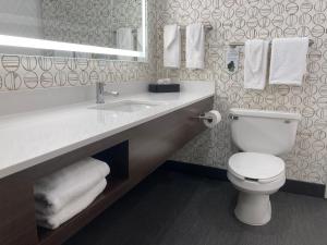 a bathroom with a toilet and a sink with towels at Holiday Inn Niagara Falls-Scenic Downtown, an IHG Hotel in Niagara Falls
