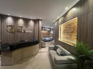 a lobby with a couch and a sign on the wall at Rotana Palace Suites in Cairo