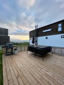 a deck with a bench and a grill on a building at Cozy central home, quiet neighbourhood in Tromsø