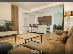 - un salon avec un canapé et une table dans l'établissement Lux Apartments, à Pristina