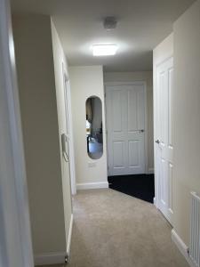 a hallway with a door and a mirror at Spacious Apartment in Brooklands in Milton Keynes