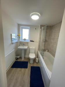a bathroom with a toilet and a sink and a shower at Spacious Apartment in Brooklands in Milton Keynes