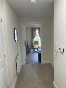 a hallway leading to a room with a window at Spacious Apartment in Brooklands in Milton Keynes