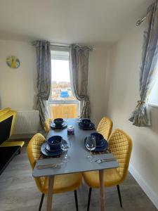 a dining room table with chairs and plates and wine glasses at Spacious Apartment in Brooklands in Milton Keynes
