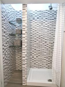 een badkamer met een douche met witte en zwarte tegels bij THE BAC HOUSE - Maestrale in Fano