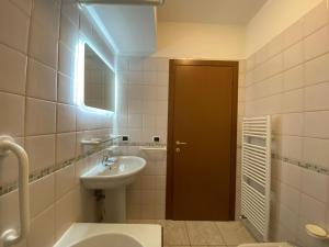 uma casa de banho com um lavatório, um WC e uma porta em Cometa Beach House em Chioggia