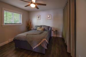 a bedroom with a bed and a ceiling fan at Fishes & Nemos Cottage in Battersea