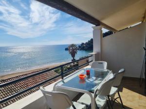 a table and chairs on a balcony with a view of the ocean at Corfu Dream Holidays Villas in Glyfada
