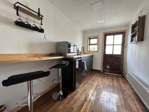 a kitchen with a counter and stools in a room at Downtown’s Sweet House in Puerto Natales