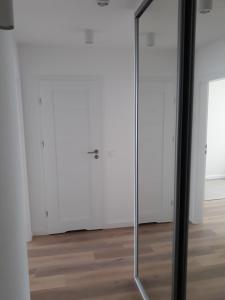 a glass door in a room with white walls at Apartament Krasiczyńska in Warsaw