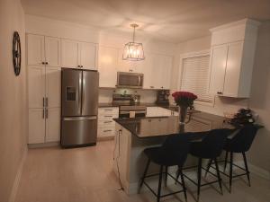 a kitchen with white cabinets and a stainless steel refrigerator at Dorothy's Deluxe room in Ottawa