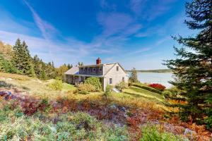 a house on top of a hill next to a body of water at Pigeon Hill Retreat in Steuben