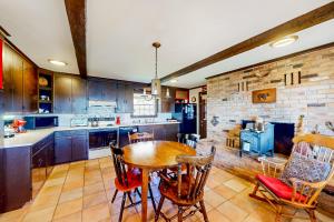 a kitchen with a wooden table and a brick wall at Pigeon Hill Retreat in Steuben