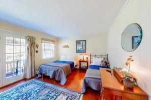 a bedroom with two beds and a mirror at Pigeon Hill Retreat in Steuben