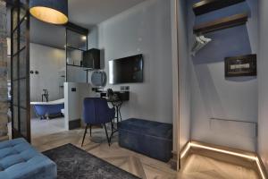 a living room with a blue couch and a tub at FORVM bijoux ROOMS in Trieste