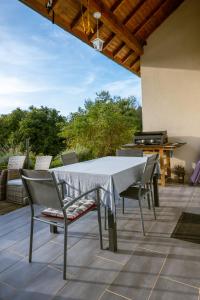 - une table et des chaises sur une terrasse avec barbecue dans l'établissement Le Saint-Christophe, à La Tour-du-Meix