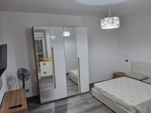 1 dormitorio con espejo y 1 cama. en Nuovaiegi en Isola Capo Rizzuto