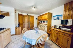 eine Küche mit einem Tisch und Stühlen im Zimmer in der Unterkunft Eden des Houches Furnished flat in Les Houches
