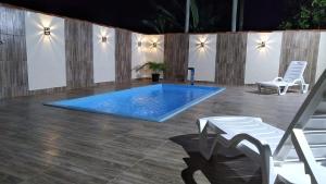 a swimming pool with two chairs and a table at Chalé Raio de Sol in Marau