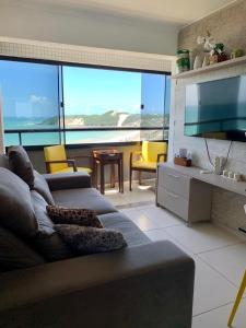 een woonkamer met een bank en uitzicht op de oceaan bij Duas suítes com a melhor vista de Ponta Negra! in Natal