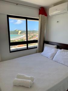 een slaapkamer met een wit bed en een groot raam bij Duas suítes com a melhor vista de Ponta Negra! in Natal