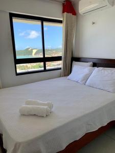 een slaapkamer met een groot wit bed en een raam bij Duas suítes com a melhor vista de Ponta Negra! in Natal