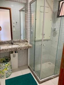 een badkamer met een glazen douche en een wastafel bij Duas suítes com a melhor vista de Ponta Negra! in Natal