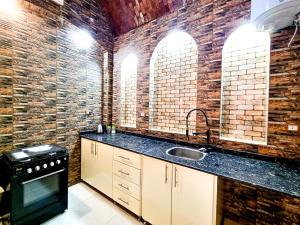 a kitchen with a sink and a brick wall at The House Of Love in Luxor +29 photos