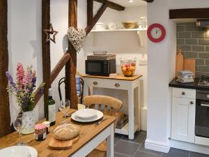 a kitchen with a table with wine glasses on it at Lavenham Red Brick Cottage in Lavenham